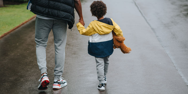 child and father walking to school